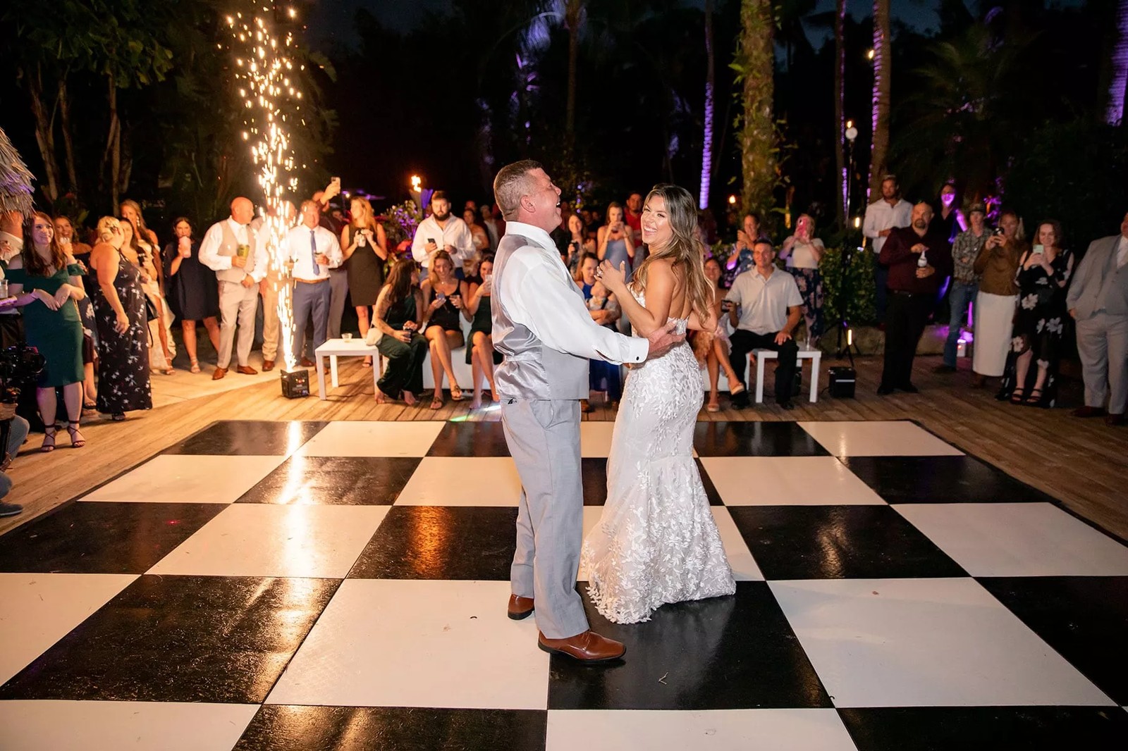Couple dancing energetically on a wood dance floor at an outdoor tented Phoenix reception